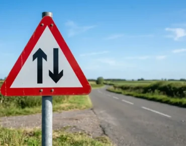 What is the two way traffic sign - UK red triangle warning sign with two arrows on a country road