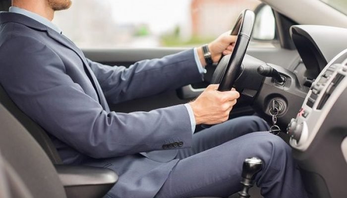 transport, business trip, destination and people concept - close up of young man in suit driving car